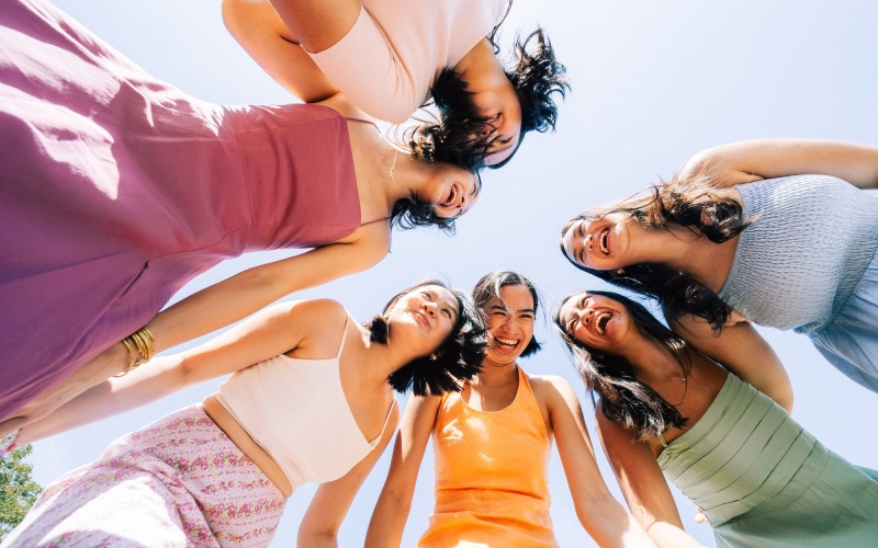 a group of girls standing in a circle looking down